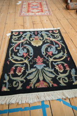 Looped pile texture of a vintage Savonnerie rug with colorful floral blossoms.