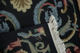 Close-up of looped pile, fringe, and Savonnerie floral motifs in black, blue, and blush.