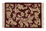 Vintage Arts and Crafts Indian rug with sprawling beige serrated leaves on a carved burgundy background.