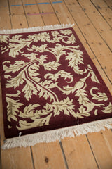 A low angle view of the vintage Indian rug, showing the carved texture of its sprawling leaf design.