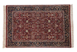 Fine Indian Tabriz design rug with a cherry red field, intricate floral vines, and a dark navy blue border.
