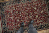 Vintage Indian Tabriz rug viewed from above, highlighting the cherry red field and floral vines.