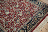 Plush cherry red pile and navy floral border detail on a fine Indian Tabriz design rug.
