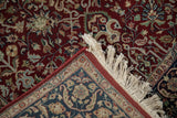 Folded corner of a fine Tabriz rug showing the plush wool pile, navy border, and clean ivory fringe.