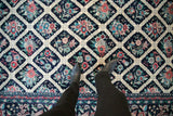 Detailed view of the Savonnerie carpet's ivory lattice design filled with colorful floral bouquets.