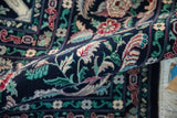 A rolled view of a vintage Pakistani rug showing the even, short wool pile and intricate floral design.