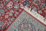 Cherry red floral pile of the Kashan rug with its intricately patterned blue reverse.