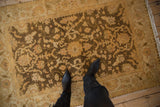 Lustrous wool pile of a vintage Oushak rug with an allover floral design in gold and olive green.