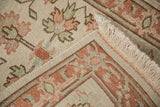 Indian Mahal rug corner showing geometric terracotta and sea foam green border with ivory fringe.