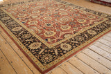 Angled view of the Indian Mahal carpet's corner showing the dark palmette border and rust floral field.