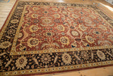 Dark chocolate brown palmette border framing the rust and gold allover design of a vintage Mahal carpet.