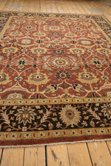 Angled view across the rich copper field and dark palmette border of a Mahal design carpet.