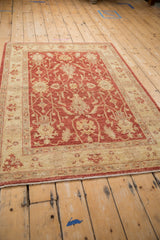 Detail of the Peshawar rug, featuring pale cherry red floral palmettes and ivory interconnecting vines.