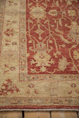 Peshawar rug showing cherry red field palmettes, beige border, and side selvage.