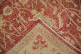 Peshawar rug corner showing red floral pile, intact side cord, and woven foundation.