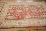 Vintage Peshawar rug: textured pale cherry red field with ivory palmettes and vines.