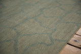 Abrashed ground and interconnected vine pattern in dusty celadon green Indian carpet.