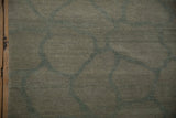 Close-up of Indian abstract carpet, showing abrashed dusty green ground with fieldstone pattern.