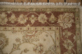 Traditional Indian Mahal rug corner with cream fringe and copper, beige floral vine border.