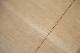 Beige open field abrashes on contemporary Gabbeh rug with red seed border.