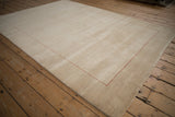 Beige contemporary Gabbeh rug corner with subtle abrash and delicate red dotted border.