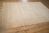 Corner of the contemporary Indian Gabbeh rug with thin red checkered seed border.
