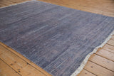 Hand-knotted Indian Modern Abstract rug corner with faded blue abrashes and cream fringe.