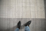 Contemporary Gabbeh rug's silver paneled field, simple plant and wave motifs, gray abrashes.