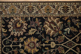 Black rug field with dusty gold, teal floral palmettes and a beige meandering vine border.