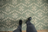 Low pile contemporary Indian Soumac carpet with textured green and ivory medallions.