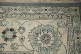 Indian Mahal rug corner with slate blue pinwheel blossoms, scrolled vines, and geometric boteh borders.