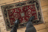 Burgundy red Indian Sarouk design rug mat with bursting floral medallion, navy cartouche border.