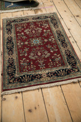 Indian Sarouk design rug, burgundy floral field with navy and beige cartouche border.