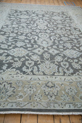 Distressed Agra rug section showcasing pale ecru floral patterns on a dark silver field.