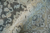 Distressed Agra carpet's rolled edge showcasing muted oxidized silver and ecru floral motifs.