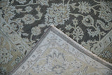 Distressed Agra carpet corner with pale ecru floral patterns on dark silver pile and original side selvage.