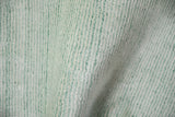 Abstract Indian rug's sea foam green, ivory platinum striations and soft luster.