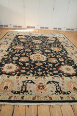 Floor-level perspective of the Sultanabad carpet's sprawling palmettes and wide, silver-toned border.