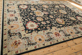 Angled view of the Sultanabad carpet's charcoal field contrasting with its wide silver border.