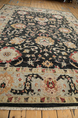 Low angle view across the plush charcoal field showing oversized palmettes and the wide Safavid border.