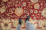Close detail of palmettes and cloud bands on the plush red field of a Sultanabad carpet.