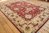 Angled view of a Sultanabad carpet's wide Safavid border and cherry red floral field.