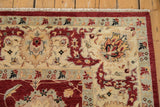 Corner detail of a Sultanabad rug's Safavid floral border in cherry red, ivory, and pale slate blue.