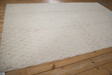 Raised simulated silk serpent pattern on an ivory contemporary Indian carpet.
