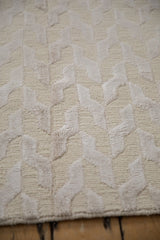 Raised serpent stylized design and looped knotted pile on the ivory contemporary carpet.