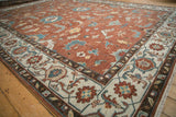 Angled view of an Indian Mahal carpet's corner, detailing the ivory turtle samovar border and copper field.
