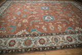 Angled view of a Mahal carpet showing its turtle samovar border and copper floral field.