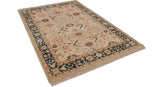 Angled view of a vintage Indian carpet, highlighting its ivory floral field and deep teal border.
