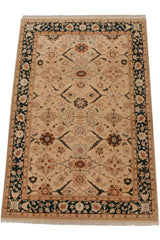 Angled view of a vintage Indian carpet with an ivory floral field and deep teal border.