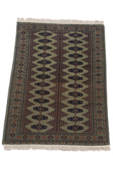 Vintage Siberian Bokhara rug from an angle, showing the columned pattern and white fringe.
